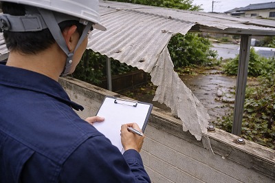 波板工事専門店の職人が劣化した波板屋根を点検している様子｜割れや固定状態を確認する現地調査の風景