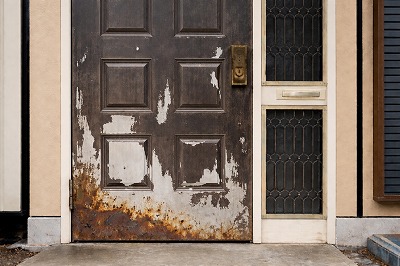 塗膜が剥がれ下地が露出している玄関扉の劣化状態が分かる写真