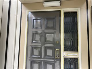 ケレン後の玄関扉に上塗り1回目を行っている塗装工事の施工写真